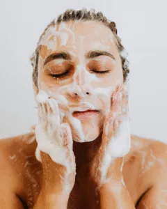 Woman washing face gently with pH-balanced cleanser – skincare mistakes that cause pimples